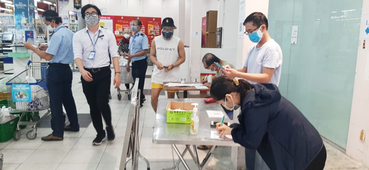 Người dân khai báo y tế trước khi vào siêu thị.
