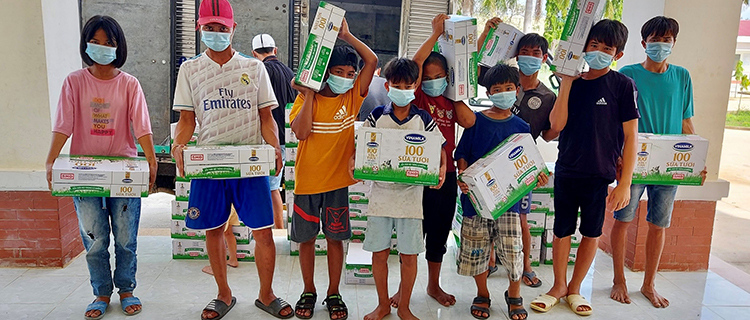 Hình ảnh đáng yêu của các em tại Trung tâm Bảo trợ và Công tác Xã hội Kon Tum đang phụ các thầy cô chuyển sữa vào trong.