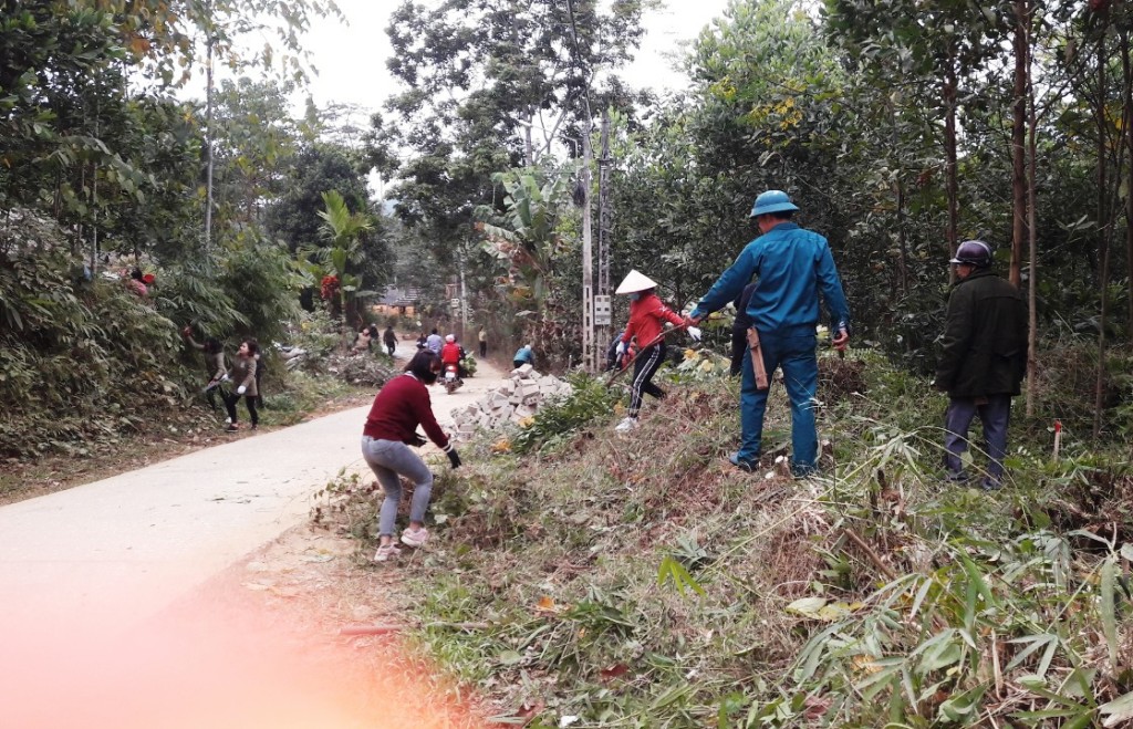Người dân Lục Yên cưa cây đập tường rào phục vụ mở rộng đường.